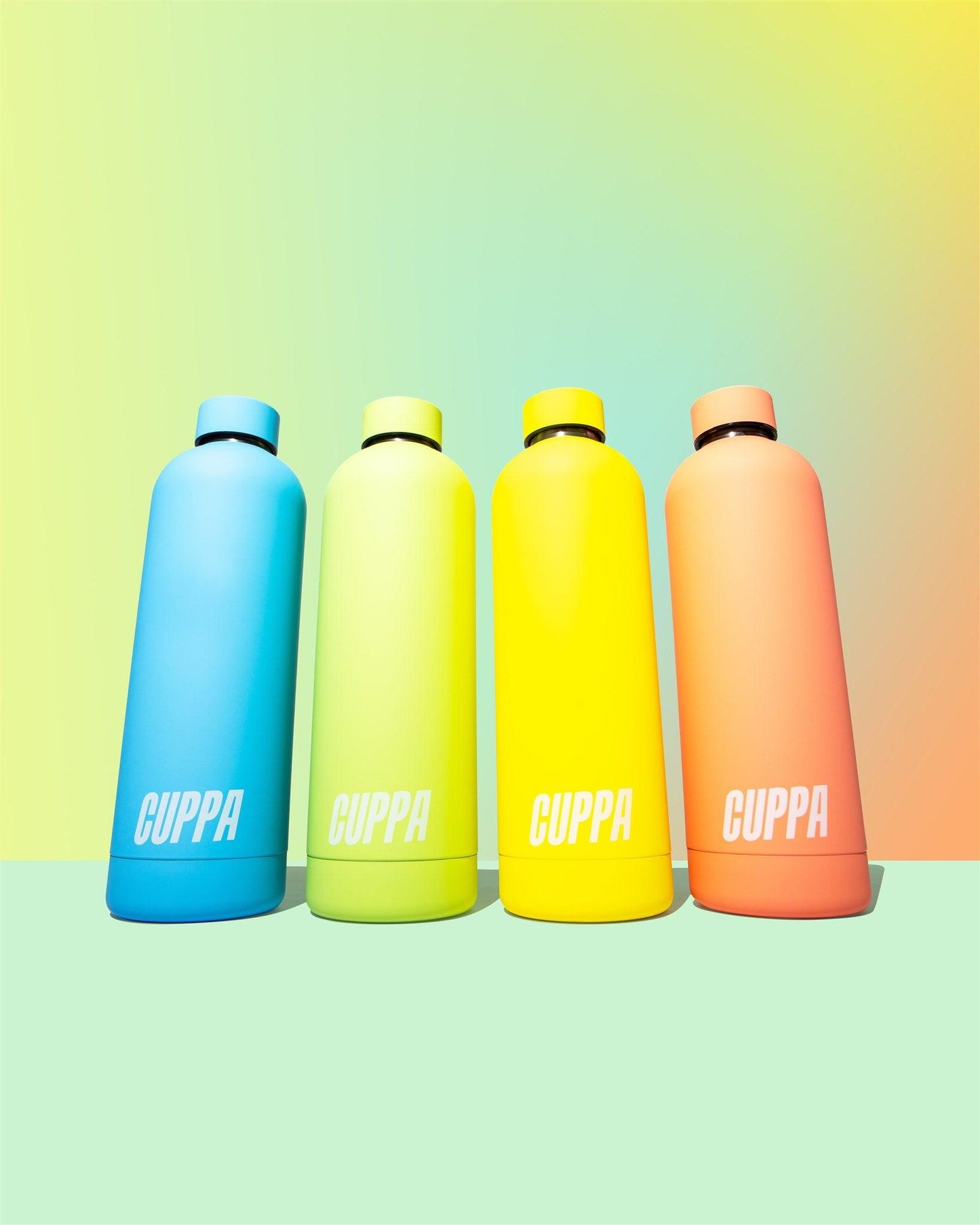 Cuppa water bottles in yellow blue green orange on multi-coloured rainbow gradient background portrait