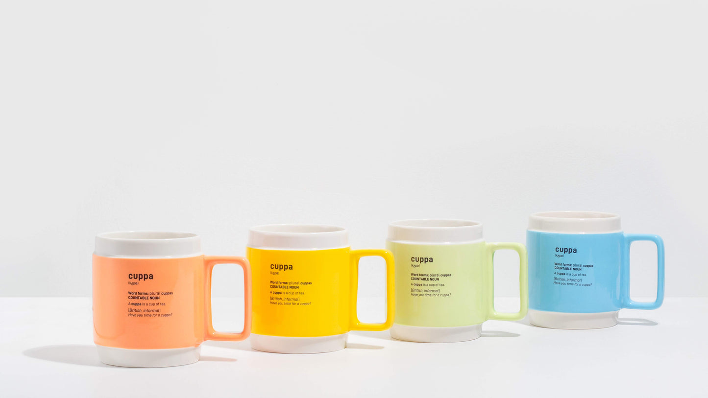 Cuppa Mugs arranged on a white background. The picture show the terracotta orange cuppa mug, the bright blue cuppa mug, the bright yellow cuppa mug and the pastel green cuppa mug.