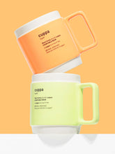 Load image into Gallery viewer, Cuppa 350ml large tea or coffee mugs on an orange background. The terracotta orange mugs is at the top and balanced on the top of the pastel green cuppa mug. Both mugs have rectangular handles that sit comfortable in the hand.
